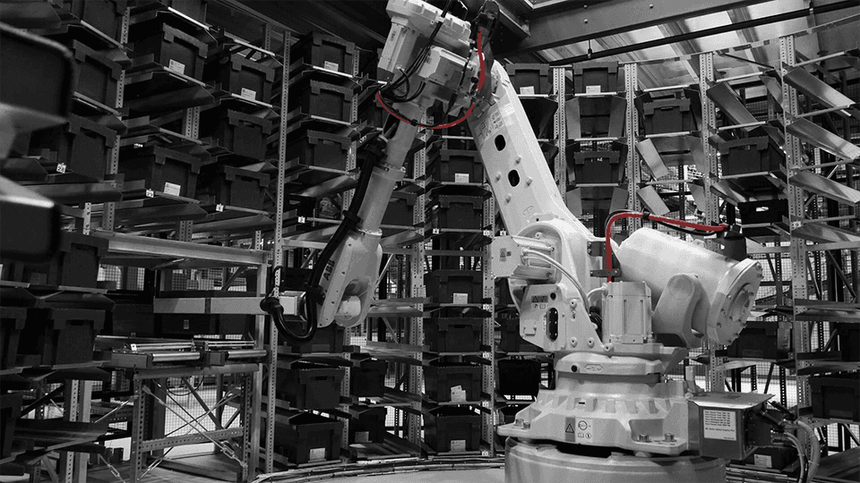 Robotic automation system in an industrial warehouse managing storage bins