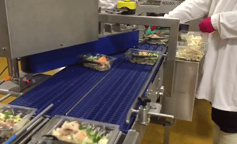 Converger conveyors on production line transporting food in a warehouse