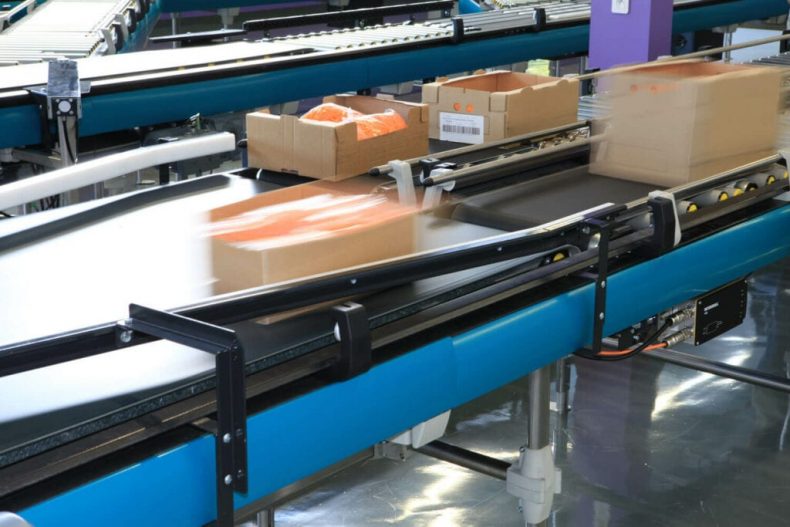 Items being transported on belt conveyor systems in a warehouse.